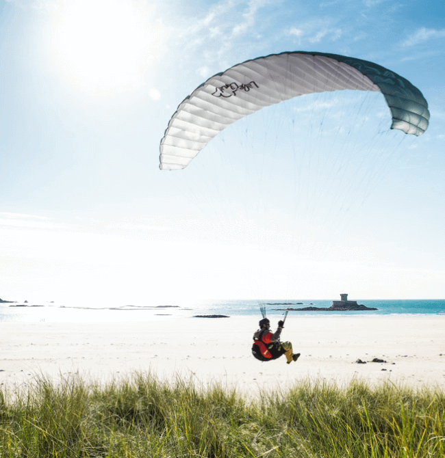 Person paragliding over St. Ouen's Bay